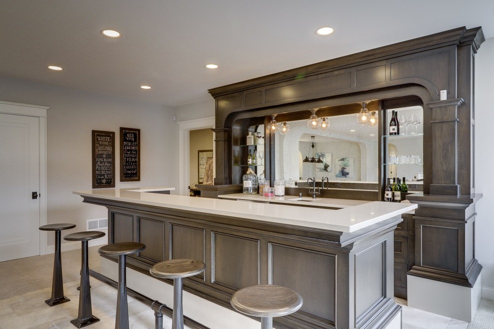 Mid-sized contemporary single-wall seated home bar in Minneapolis with no sink, beaded inset cabinets, dark wood cabinets, solid surface benchtops, mirror splashback, light hardwood floors, beige floor and white benchtop.