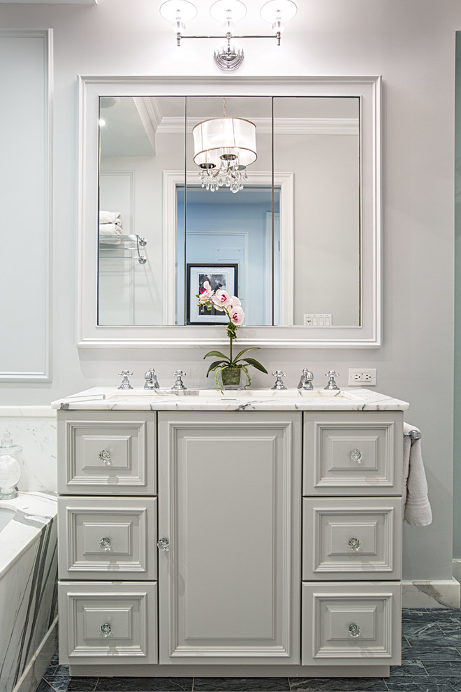 Inspiration for a traditional bathroom in New York with raised-panel cabinets and white cabinets.