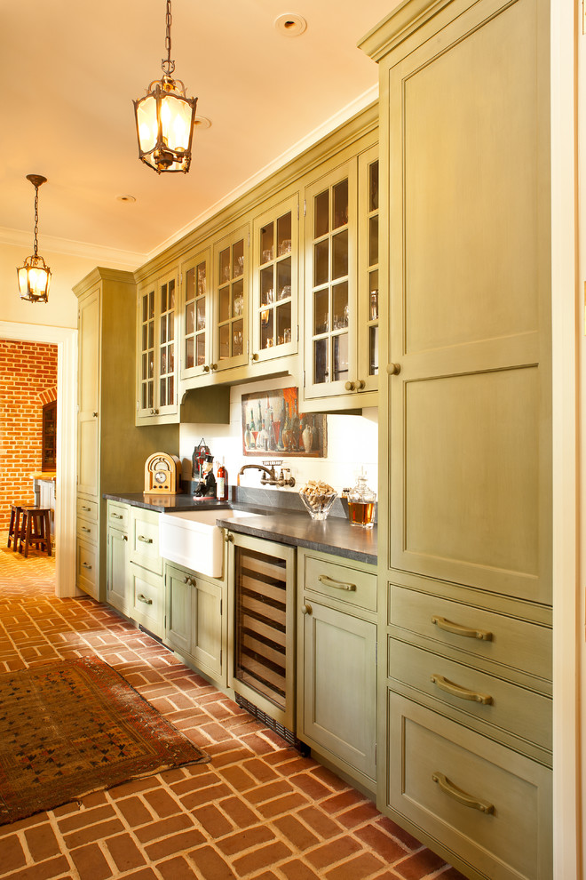 Inspiration for a traditional kitchen in Atlanta with a farmhouse sink, recessed-panel cabinets, green cabinets and brick floors.