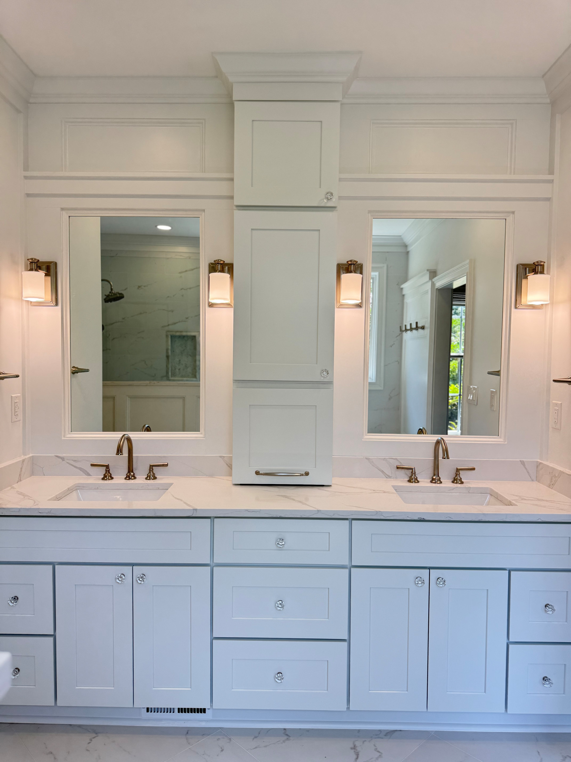 This custom built vanity achieves a built in look using accented trim. The upper cabinets were recessed into the bumped out wall giving the client more storage without sacrificing countertop space.