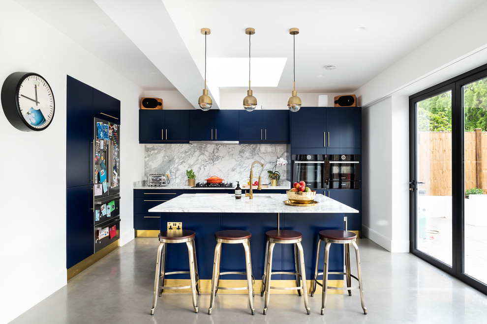 Mid-sized contemporary galley kitchen in London with an undermount sink, flat-panel cabinets, blue cabinets, white splashback, stone slab splashback, black appliances, concrete floors, with island, grey floor and white benchtop.