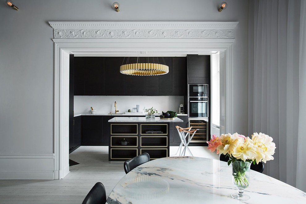 This is an example of a large contemporary l-shaped eat-in kitchen in Gothenburg with a single-bowl sink, flat-panel cabinets, black cabinets, marble benchtops, black appliances, light hardwood floors and with island.