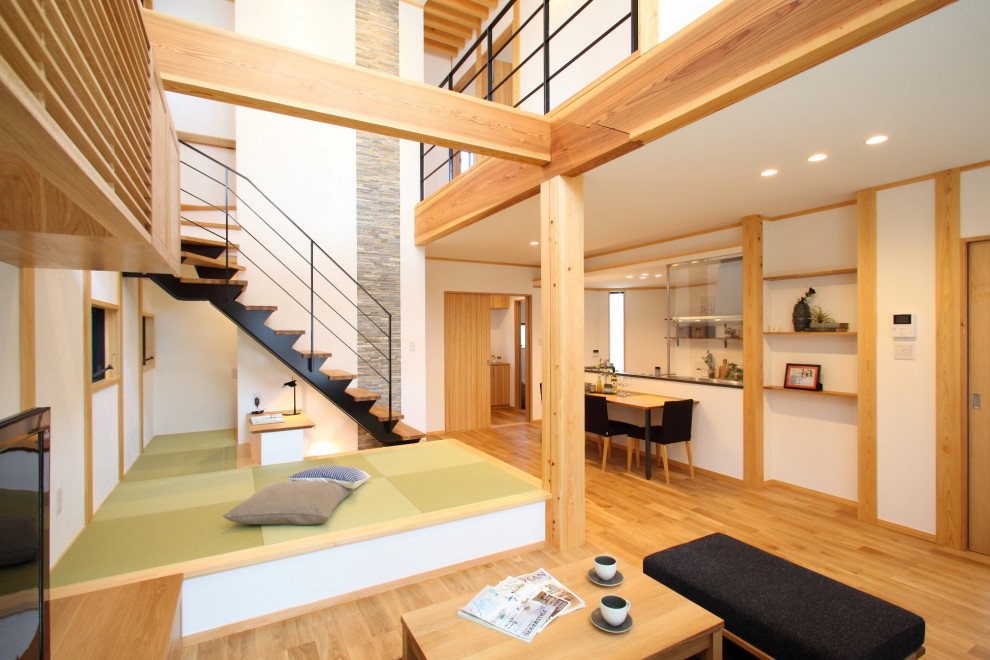 Photo of a mid-sized modern wood l-shaped staircase in Tokyo with open risers and metal railing.