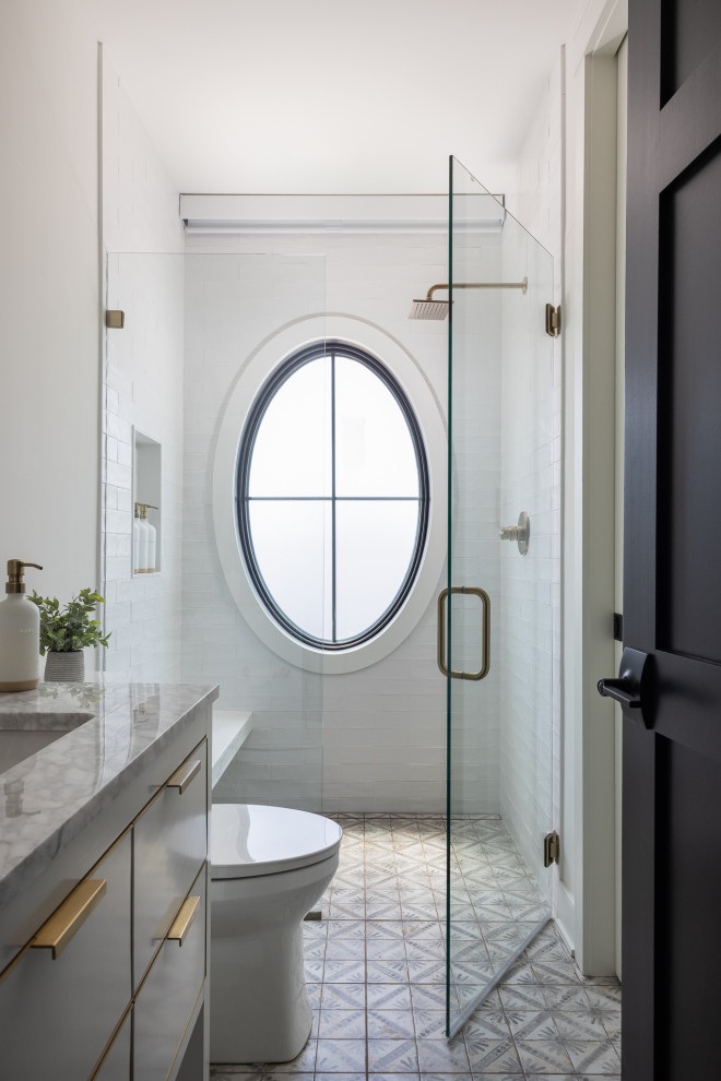 Inspiration for a coastal white tile gray floor and single-sink alcove shower remodel with flat-panel cabinets, gray cabinets, white walls, an undermount sink, a hinged shower door, gray countertops, a niche and a freestanding vanity