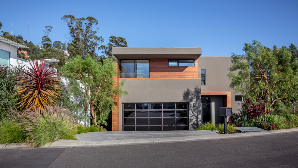This is an example of a gey modern detached house in San Francisco with three floors, wood cladding, a flat roof and a white roof.