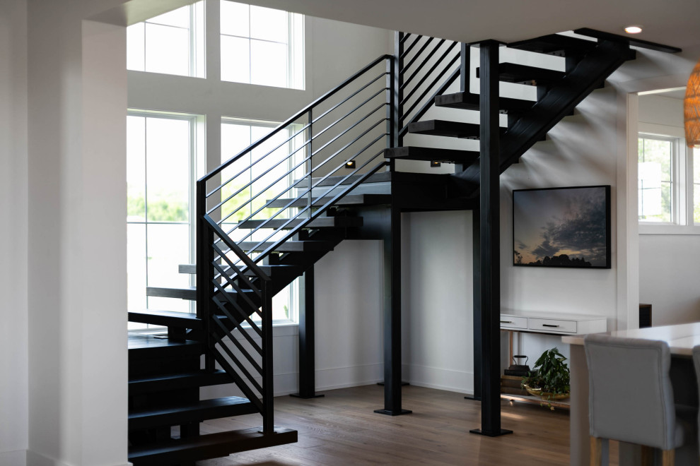 Design ideas for a large country wood u-shaped metal railing staircase in Nashville with metal risers.