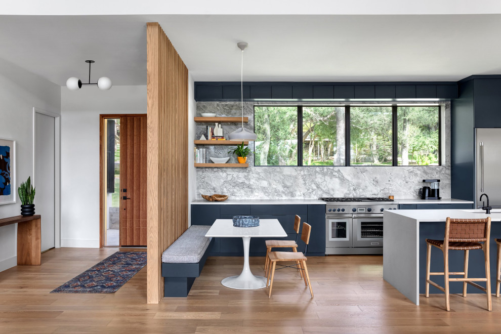 Design ideas for a large midcentury galley eat-in kitchen in Austin with an undermount sink, flat-panel cabinets, blue cabinets, quartz benchtops, grey splashback, marble splashback, stainless steel appliances, light hardwood floors, a peninsula and white benchtop.