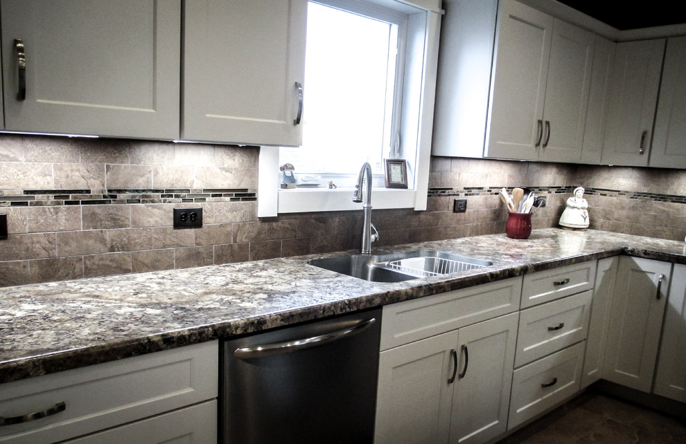 Transitional vinyl floor eat-in kitchen photo with white cabinets, beige backsplash, stainless steel appliances and an island