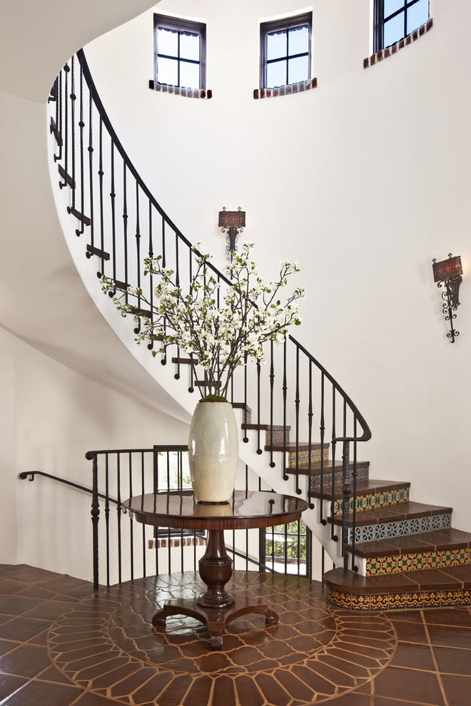 Photo of an expansive mediterranean tile curved staircase in Los Angeles with tile risers.