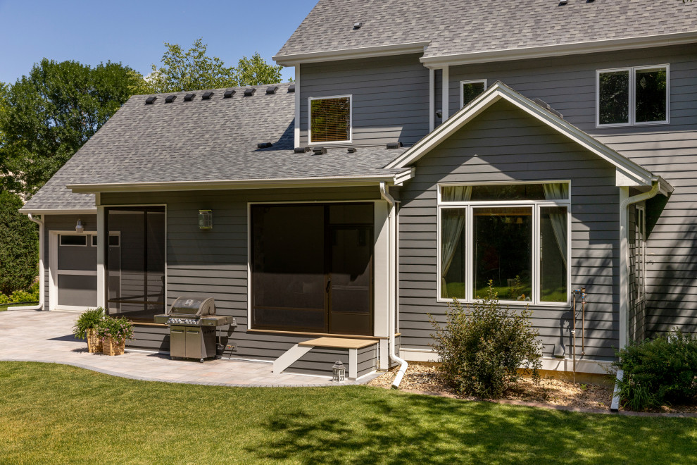 This is an example of a large traditional three-storey grey house exterior in Minneapolis with wood siding, a shed roof, a shingle roof, a grey roof and shingle siding.