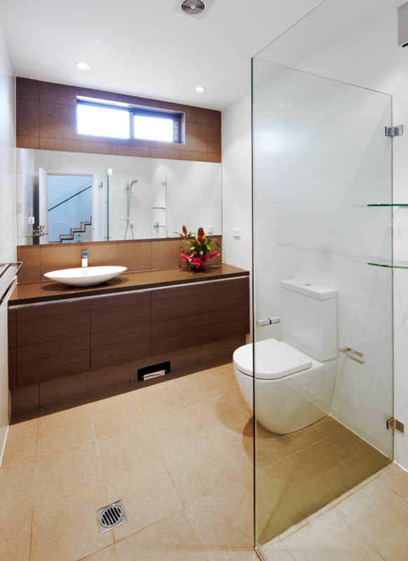 Photo of a mid-sized contemporary kids bathroom in Sydney with dark wood cabinets, flat-panel cabinets, a corner shower, a two-piece toilet, ceramic tile, ceramic floors, a vessel sink, beige floor, a hinged shower door and brown benchtops.