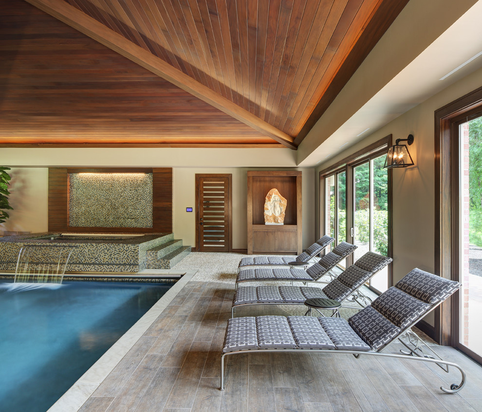 Inspiration for a contemporary indoor rectangular pool in Cleveland with a water feature and decking.