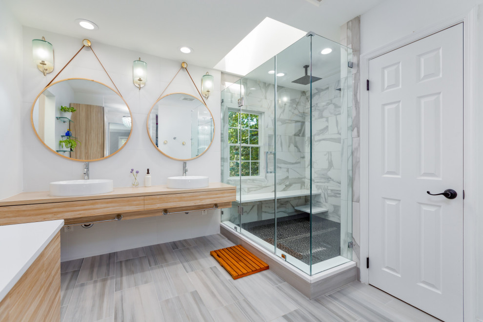 Inspiration for a contemporary bathroom in DC Metro with flat-panel cabinets, light wood cabinets, a one-piece toilet, white tile, porcelain tile, a vessel sink, engineered quartz benchtops, a hinged shower door, white benchtops, a double vanity and a floating vanity.