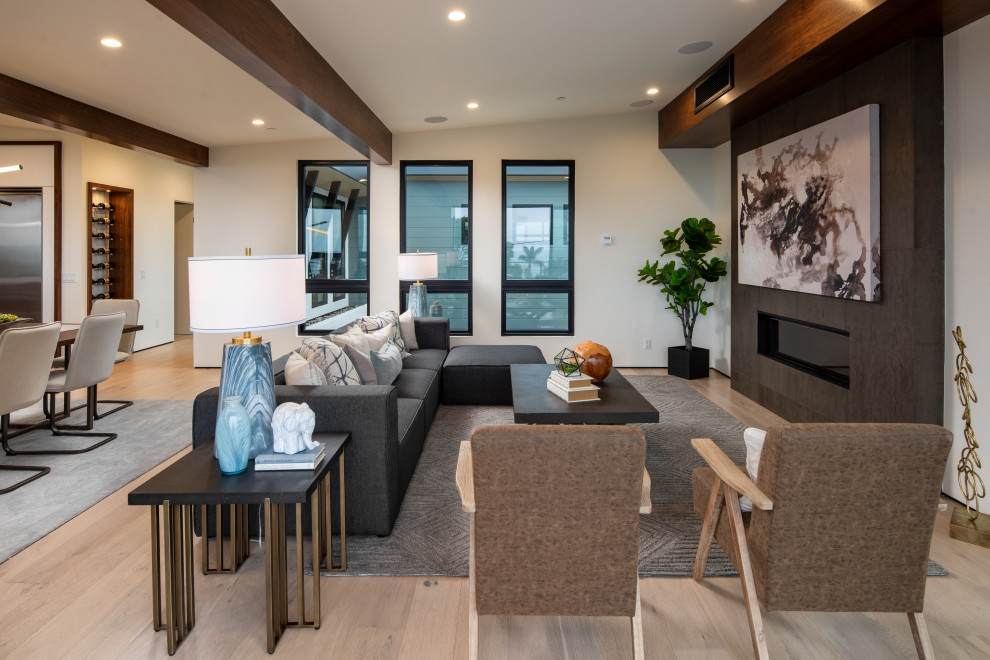 Design ideas for a large contemporary open concept living room in San Diego with white walls, light hardwood floors, a ribbon fireplace, a concrete fireplace surround and beige floor.