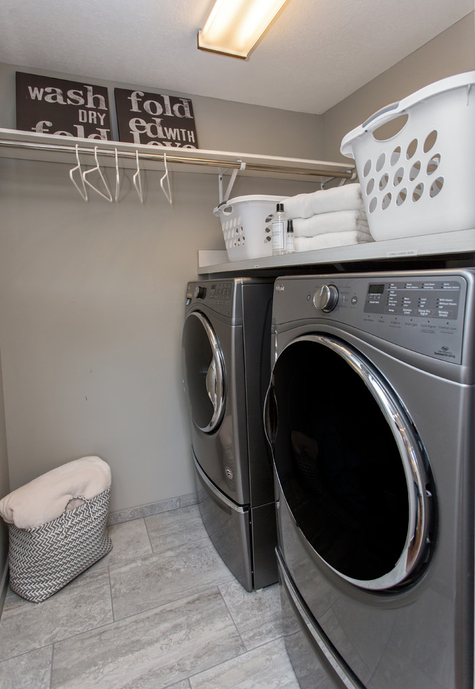 Inspiration for a large transitional u-shaped laundry room in Other with a double-bowl sink, recessed-panel cabinets, white cabinets, quartz benchtops, white splashback, marble splashback, medium hardwood floors and brown floor.