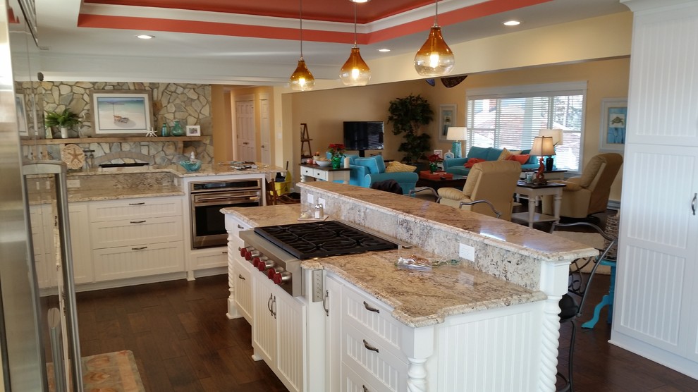 Inspiration for a mid-sized beach style l-shaped open plan kitchen in Other with an undermount sink, shaker cabinets, white cabinets, granite benchtops, stainless steel appliances, dark hardwood floors and with island.