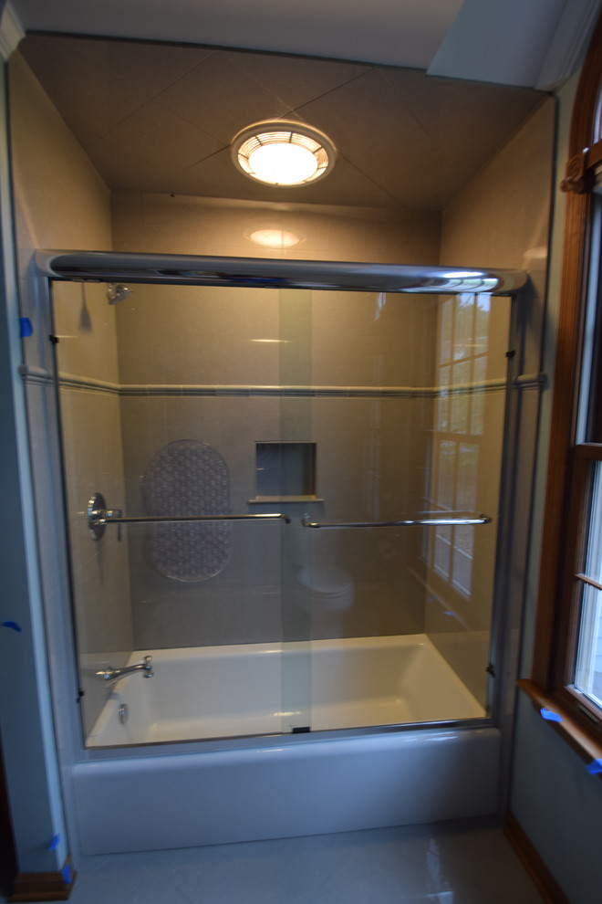 Inspiration for a mid-sized transitional kids' gray tile and porcelain tile porcelain tile and gray floor alcove bathtub remodel with raised-panel cabinets, medium tone wood cabinets, a one-piece toilet, blue walls, an undermount sink, granite countertops and multicolored countertops