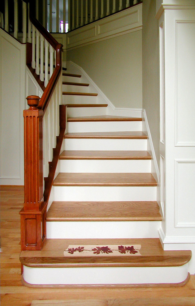 Photo of a mid-sized traditional wood straight staircase in Portland with painted wood risers.