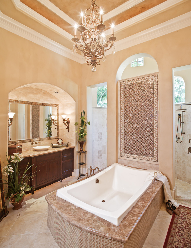 Photo of a mediterranean bathroom in Houston with furniture-like cabinets, dark wood cabinets, a drop-in tub, multi-coloured tile, mosaic tile and an alcove shower.