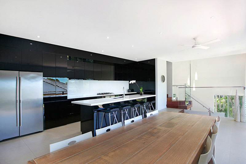Modern single-wall eat-in kitchen in Newcastle - Maitland with glass-front cabinets, black cabinets, granite benchtops, white splashback, glass sheet splashback and ceramic floors.