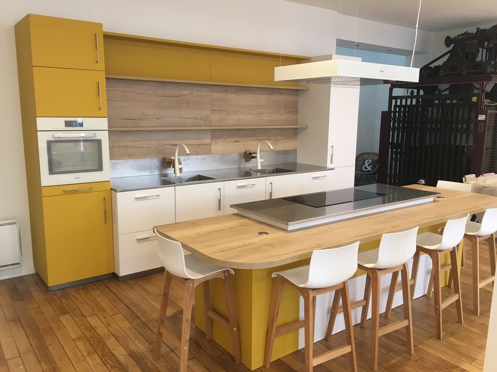 Photo of a mid-sized contemporary galley eat-in kitchen in Paris with an undermount sink, shaker cabinets, white cabinets, brown splashback, timber splashback, coloured appliances, light hardwood floors and with island.