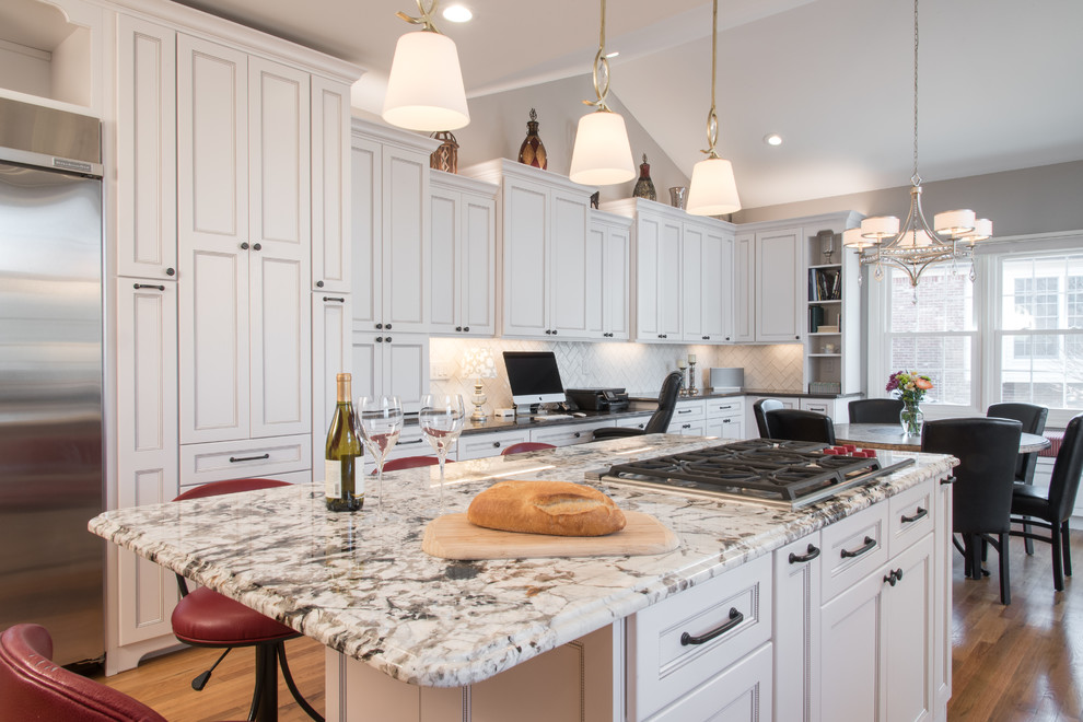 Enclosed kitchen - transitional u-shaped medium tone wood floor enclosed kitchen idea in St Louis with an undermount sink, flat-panel cabinets, white cabinets, granite countertops, white backsplash, subway tile backsplash, stainless steel appliances and an island