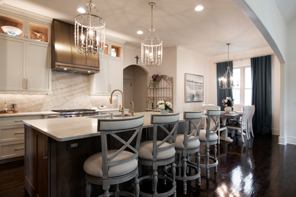 Example of a large transitional l-shaped dark wood floor and brown floor open concept kitchen design in Nashville with an undermount sink, beaded inset cabinets, white cabinets, quartzite countertops, beige backsplash, stone slab backsplash, stainless steel appliances, an island and beige countertops