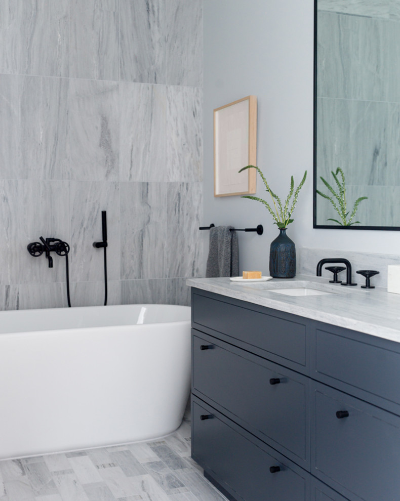 Inspiration for a midcentury bathroom in New York with flat-panel cabinets, grey cabinets, a freestanding tub, gray tile, grey walls, an undermount sink, grey floor, grey benchtops and a built-in vanity.