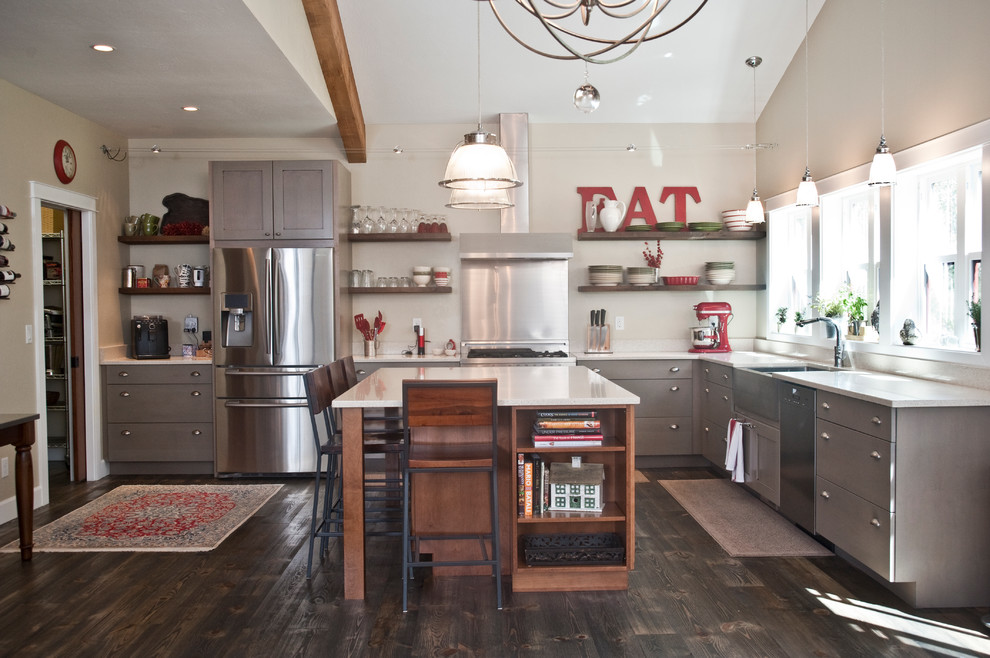 Open concept kitchen - large transitional l-shaped dark wood floor and brown floor open concept kitchen idea with a farmhouse sink, flat-panel cabinets, gray cabinets, quartz countertops, stainless steel appliances and an island