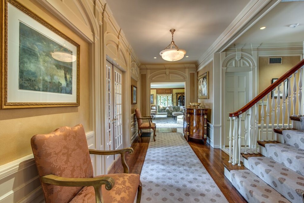 Large traditional hallway in Boston with beige walls and dark hardwood floors.