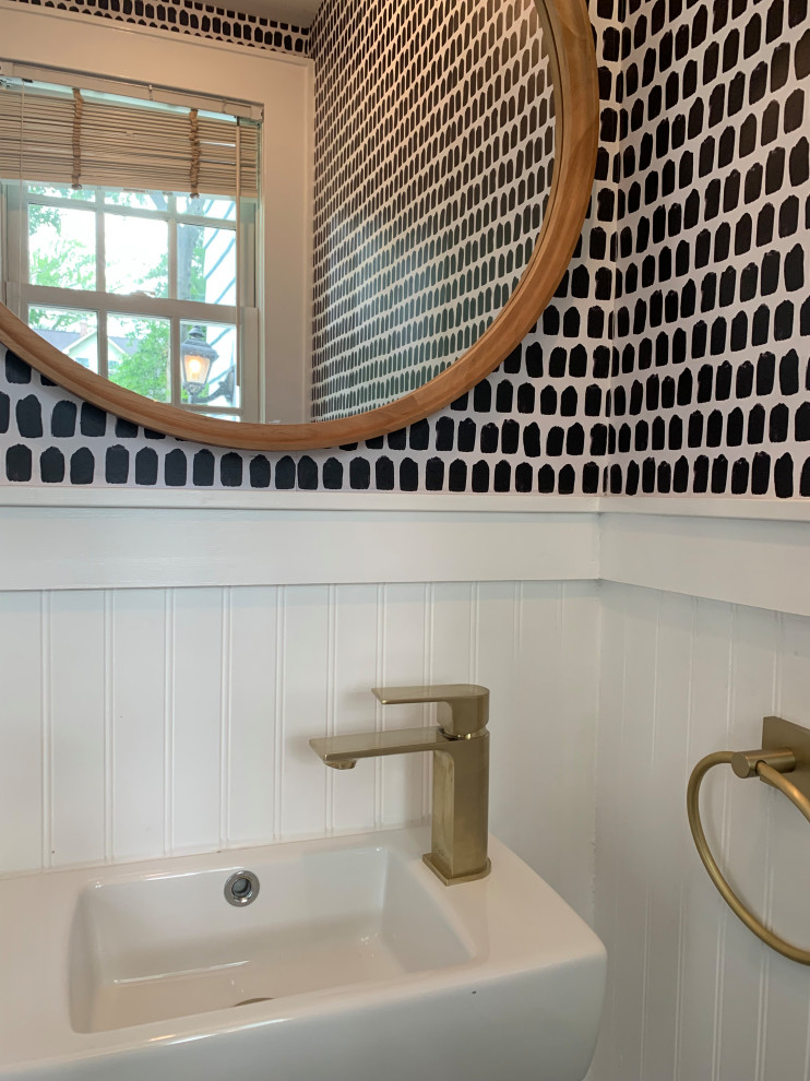 Bild på ett litet funkis toalett, med en toalettstol med separat cisternkåpa, vita väggar, mörkt trägolv, ett väggmonterat handfat och brunt golv