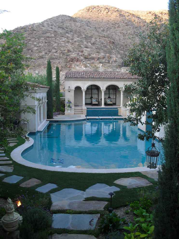 Photo of an expansive mediterranean courtyard custom-shaped natural pool in Orange County with a pool house.
