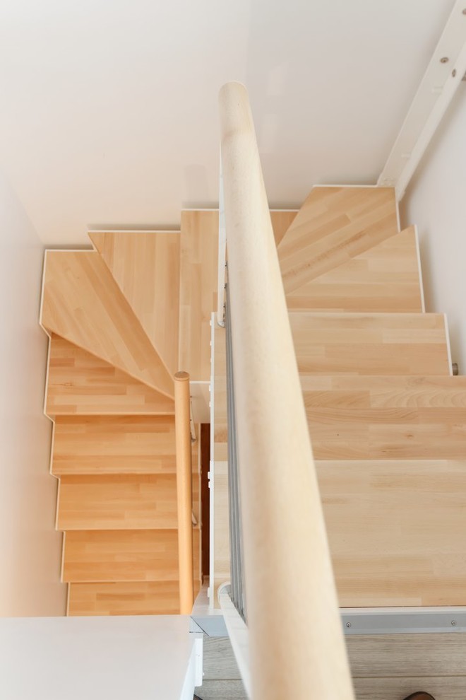 Photo of a small scandinavian wood u-shaped staircase in Paris with open risers.