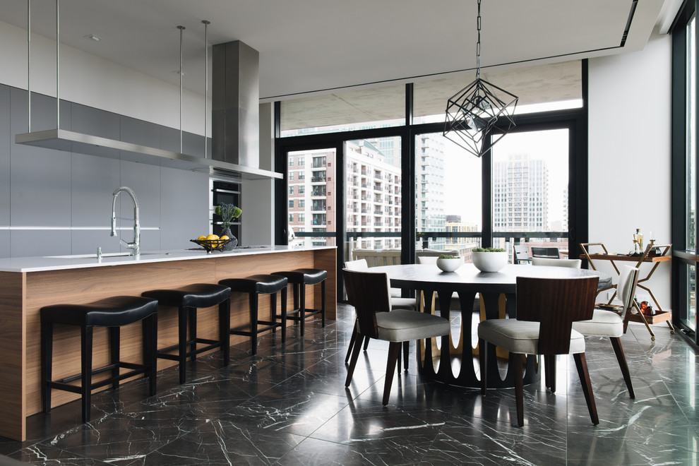 Contemporary galley eat-in kitchen in Chicago with an undermount sink, flat-panel cabinets, grey cabinets, black appliances, with island, black floor and white benchtop.