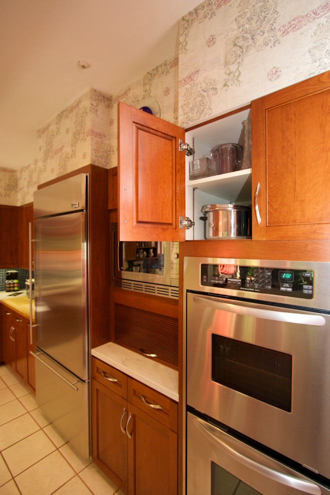 Open concept kitchen - transitional l-shaped ceramic tile open concept kitchen idea in Baltimore with an undermount sink, recessed-panel cabinets, medium tone wood cabinets, solid surface countertops, blue backsplash, ceramic backsplash, stainless steel appliances and an island