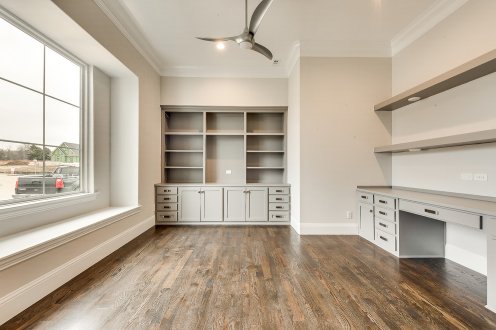 Photo of a large transitional study room in Dallas with grey walls, medium hardwood floors, a built-in desk and brown floor.