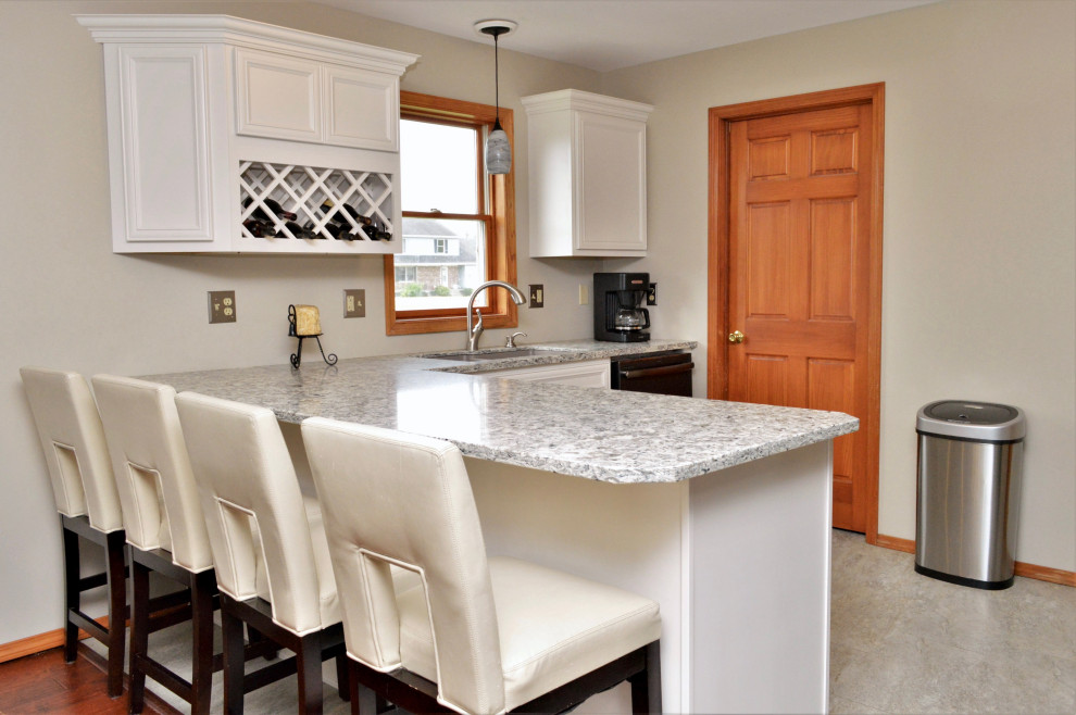 Mid-sized transitional l-shaped eat-in kitchen photo in Chicago with an undermount sink, recessed-panel cabinets, white cabinets, quartzite countertops, stainless steel appliances, a peninsula and gray countertops