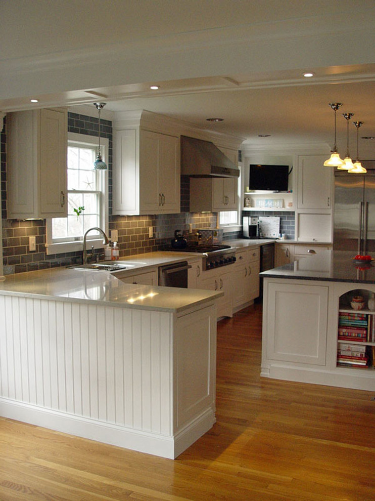 Inspiration for a large traditional u-shaped eat-in kitchen in Providence with a double-bowl sink, recessed-panel cabinets, white cabinets, grey splashback, ceramic splashback, stainless steel appliances, light hardwood floors, with island and quartz benchtops.