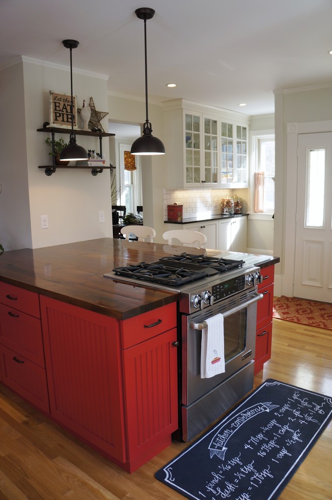 Enclosed kitchen - small rustic l-shaped light wood floor and beige floor enclosed kitchen idea in Boston with an undermount sink, recessed-panel cabinets, granite countertops, white backsplash, subway tile backsplash, stainless steel appliances, an island, white cabinets and black countertops