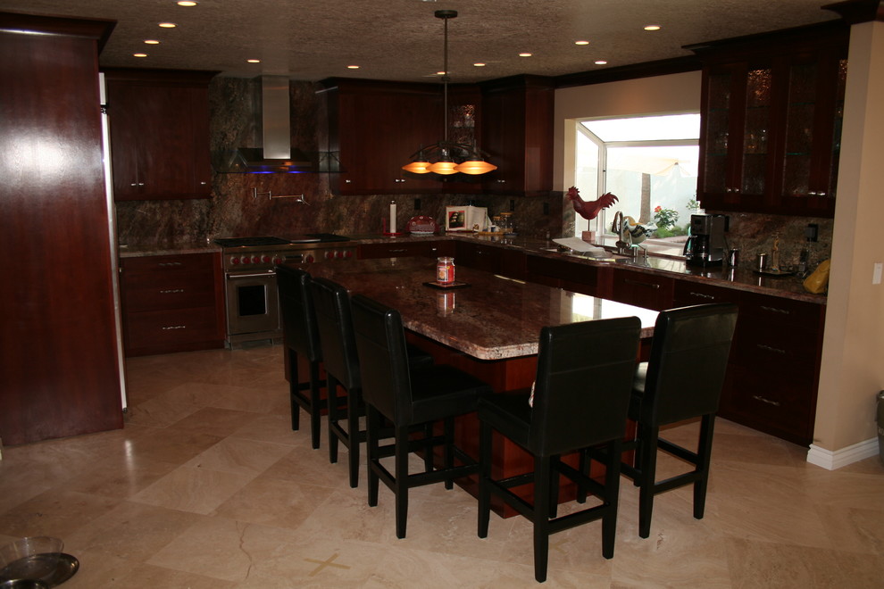 Example of a large transitional u-shaped kitchen design in Orange County with raised-panel cabinets, dark wood cabinets and stainless steel appliances
