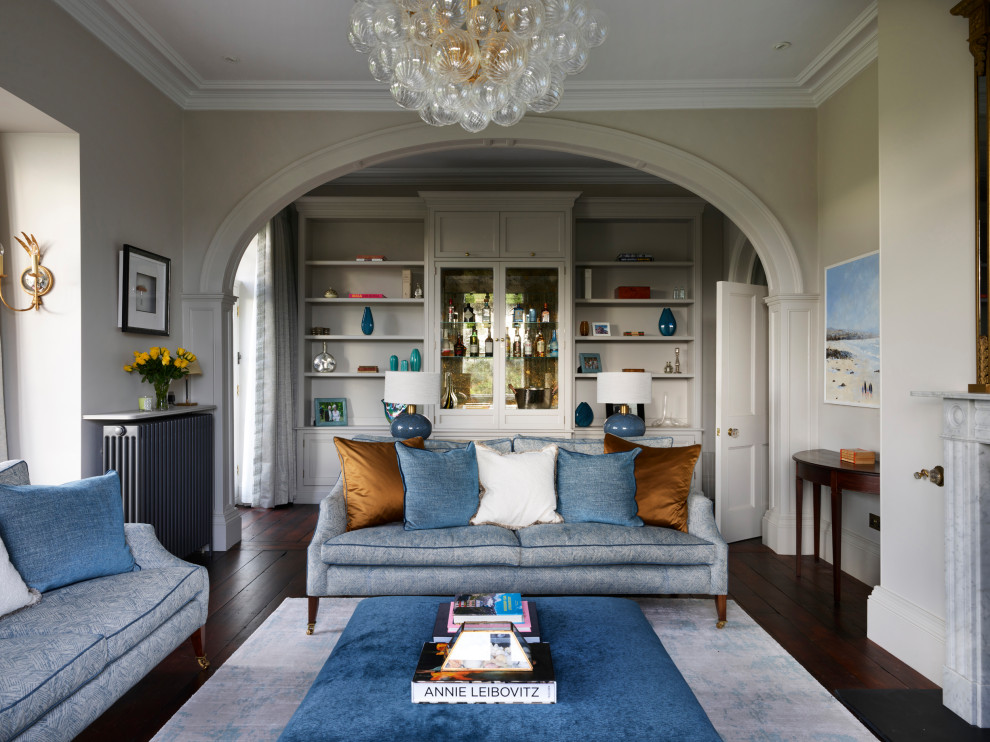 Large traditional formal enclosed living room with dark hardwood flooring, a standard fireplace, a stone fireplace surround and a wall mounted tv.