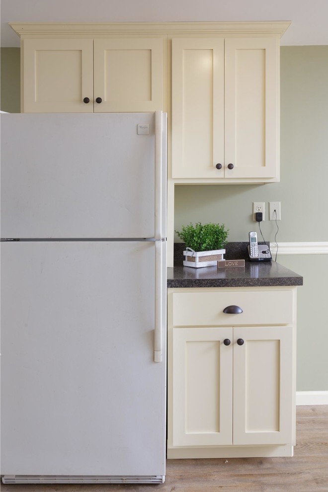 Inspiration for a mid-sized transitional u-shaped light wood floor and beige floor enclosed kitchen remodel with a double-bowl sink, shaker cabinets, white cabinets, granite countertops, black appliances, no island and gray countertops