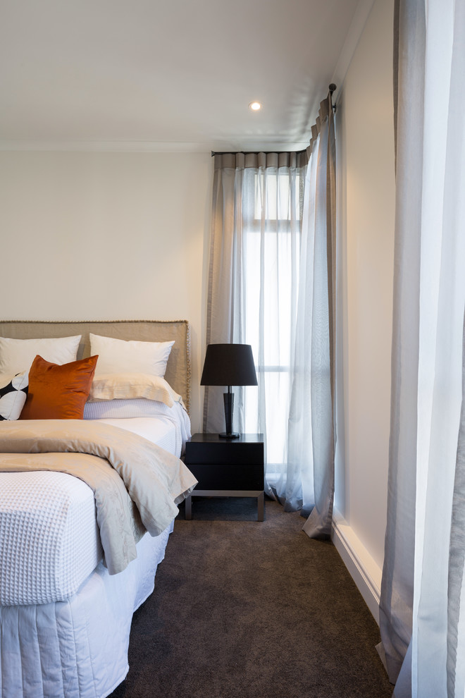 This is an example of a mid-sized contemporary guest bedroom in Auckland with white walls, carpet and grey floor.