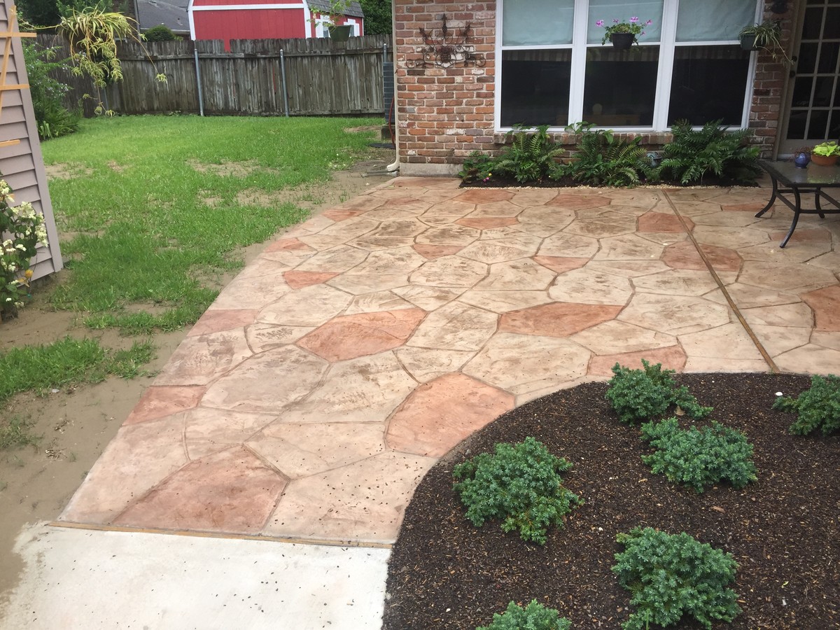 Mid-sized transitional backyard patio in New Orleans with a vertical garden, stamped concrete and a roof extension.