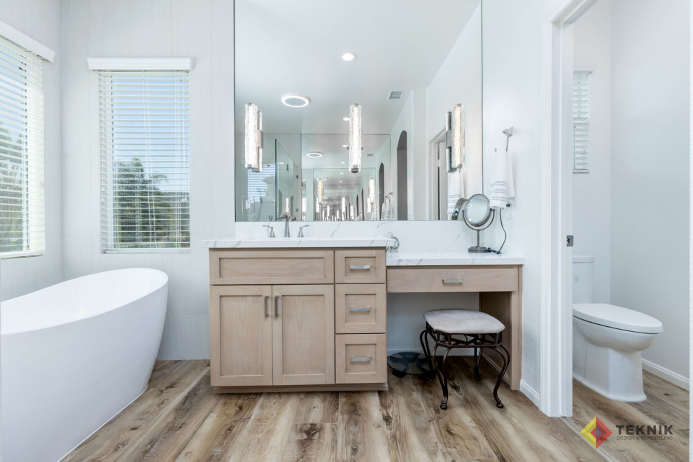 Exempel på ett stort klassiskt vit vitt en-suite badrum, med beige skåp, ett fristående badkar, en hörndusch, en toalettstol med separat cisternkåpa, grå kakel, vita väggar, vinylgolv, ett undermonterad handfat, bänkskiva i kvarts och brunt golv