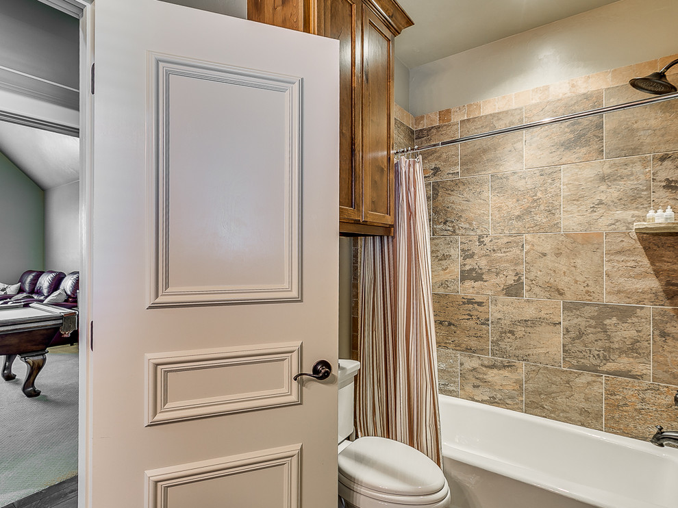 Small country kids bathroom in Oklahoma City with a drop-in sink, shaker cabinets, light wood cabinets, granite benchtops, an alcove tub, a shower/bathtub combo, a two-piece toilet, brown tile, beige walls and ceramic floors.