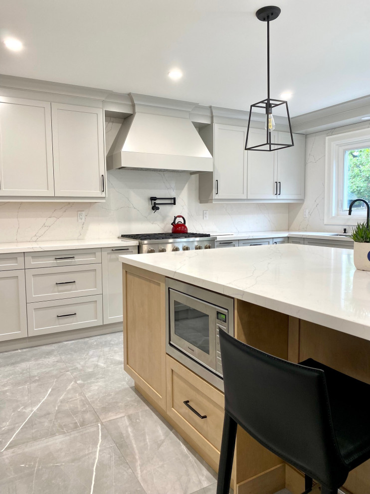 Open concept kitchen - mid-sized transitional l-shaped porcelain tile open concept kitchen idea in Toronto with an undermount sink, shaker cabinets, gray cabinets, quartz countertops, white backsplash, quartz backsplash, stainless steel appliances, an island and white countertops