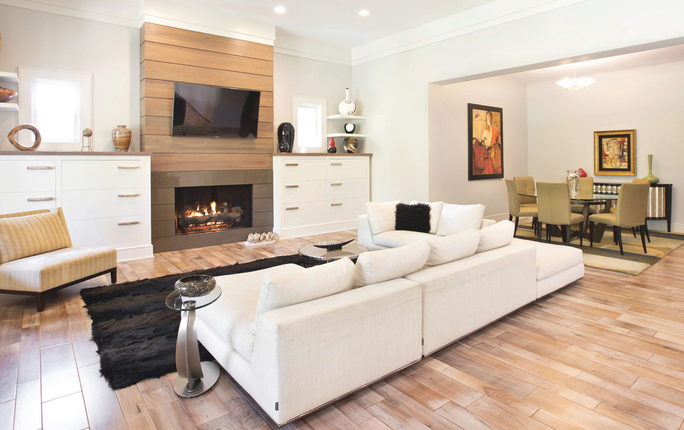 Inspiration for a large modern formal open concept living room in Indianapolis with a standard fireplace, a stone fireplace surround, a wall-mounted tv, white walls, light hardwood floors and brown floor.