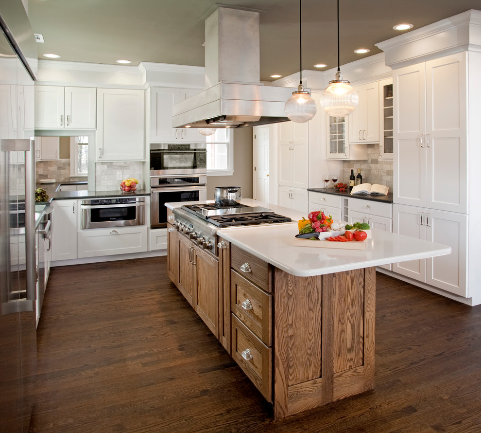 Inspiration for a large traditional l-shaped eat-in kitchen in Philadelphia with a farmhouse sink, shaker cabinets, white cabinets, granite benchtops, white splashback, stone tile splashback, stainless steel appliances, dark hardwood floors and with island.