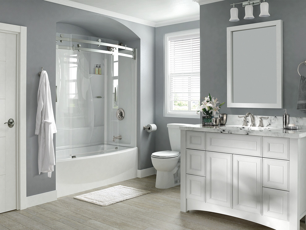 Alcove bathtub - large transitional alcove bathtub idea in Indianapolis with white cabinets, a one-piece toilet, gray walls and marble countertops